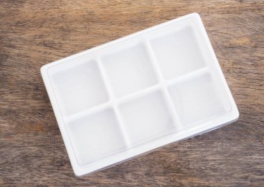 Ahşap arka plan üzerinde boş plastik gıda kabı.