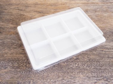 Ahşap arka plan üzerinde boş plastik gıda kabı.