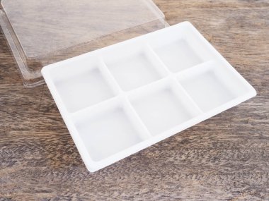 Ahşap arka plan üzerinde boş plastik gıda kabı.