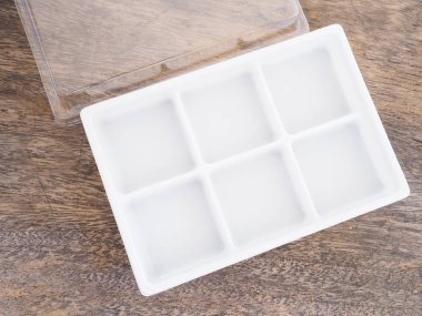 Ahşap arka plan üzerinde boş plastik gıda kabı.