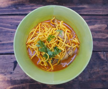 Curried şehriye çorbası tavuk (Khao Soi) üzerinde yeşil kase ile woo