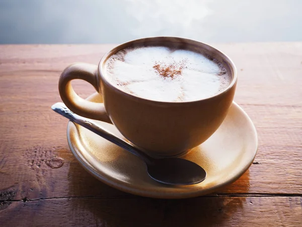 Закрыть чашку кофе на деревянном столе утром — стоковое фото