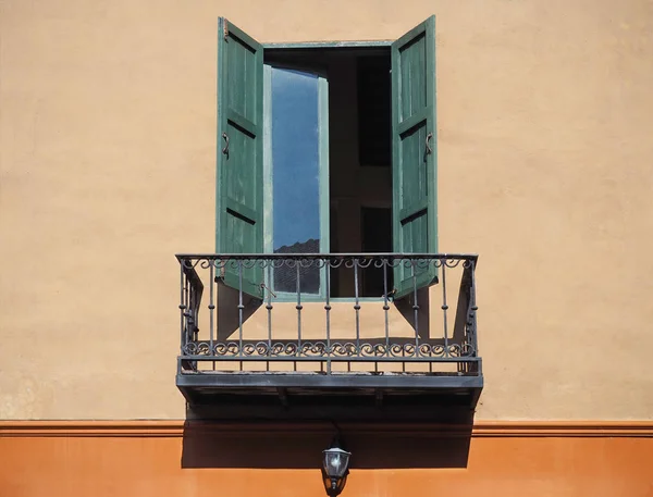 Holzfenster an orangefarbener Wand mit Balkon — Stockfoto