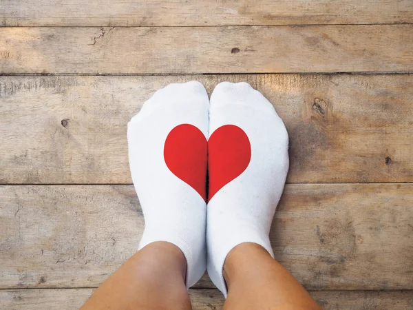 Voeten dragen witte sokken met rood hart vorm — Stockfoto