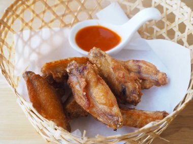 ahşap masa üzerinde bambu sepette soslu kızarmış tavuk