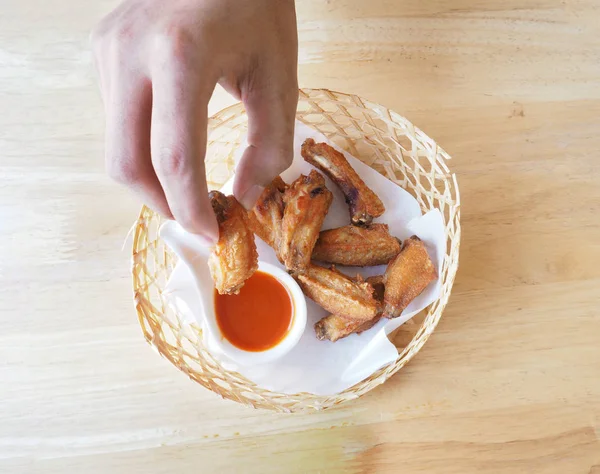 Mano umana raccogliere pollo fritto e tuffo in salsa . — Foto Stock