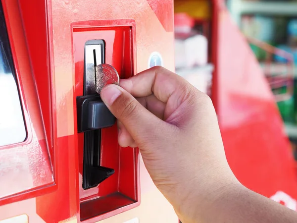 Main humaine insérant pièce dans le distributeur automatique — Photo