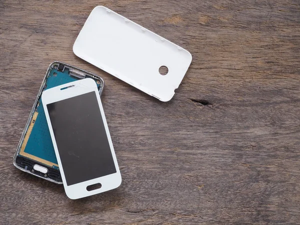Złamane inteligentny telefon na tle drewna grunge — Zdjęcie stockowe