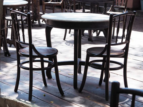 Zwarte houten ronde tafels met stoelen — Stockfoto