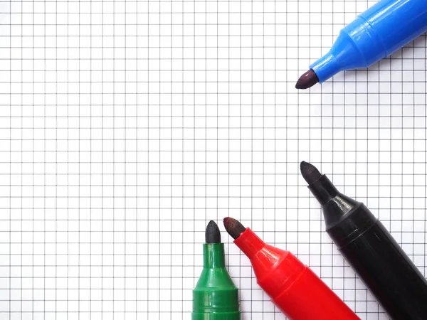 Marker pens on graph paper background. Top view. — Stock Photo, Image