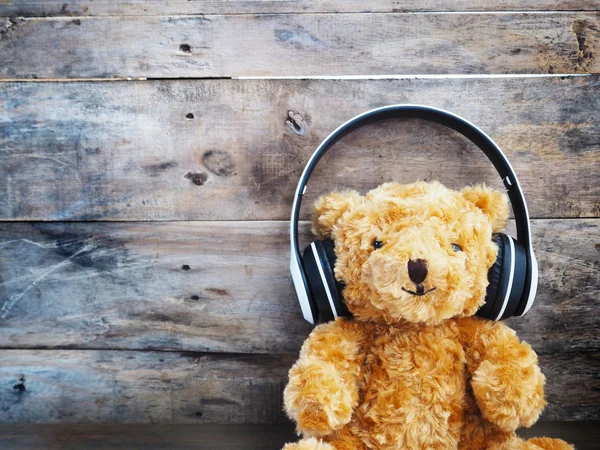 oyuncak ayı eski ahşap duvar arka plan üzerinde kulaklık