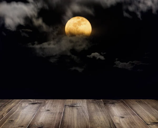 Деревянный стол в полнолуние с облаками ночью . — стоковое фото