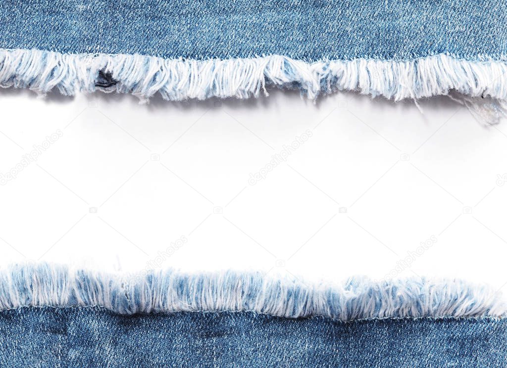 Edge frame of blue denim jeans ripped over white background.