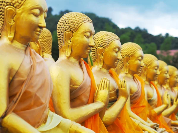 Row of golden monk statues sitting in various gestures — Stock Photo, Image