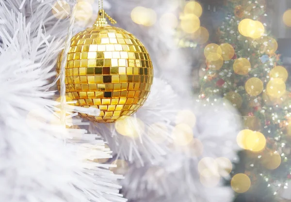 Закрыть золотые блестящие шарики на белой елке — стоковое фото