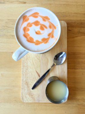 Beyaz fincan süt köpük yüzey ile Tay turuncu çay