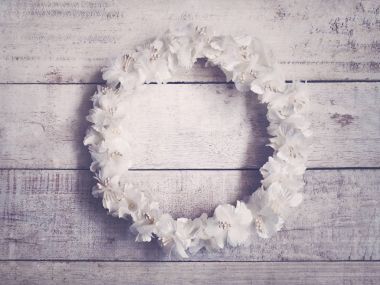 Ahşap arka plan üzerinde beyaz çiçek çelenk. Daire düğün dekorasyon için çerçeve çiçek. Vintage filtre efekti.