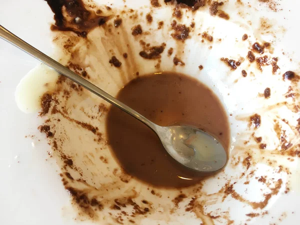 Spoon in white bowl of tasty melted chocolate icecream after eat — Stock Photo, Image