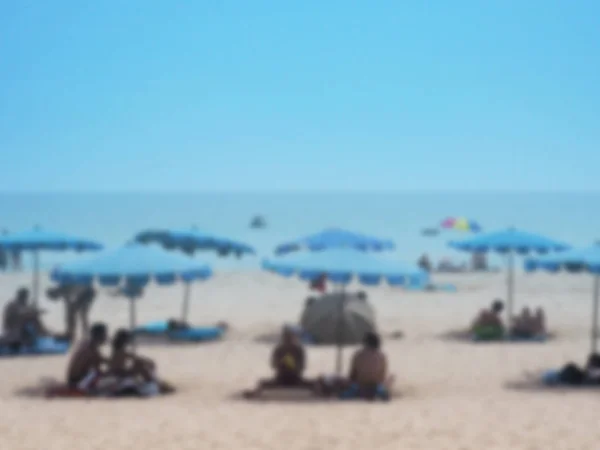 Abstrakta suddig bakgrund av sommar strand med personer sola — Stockfoto