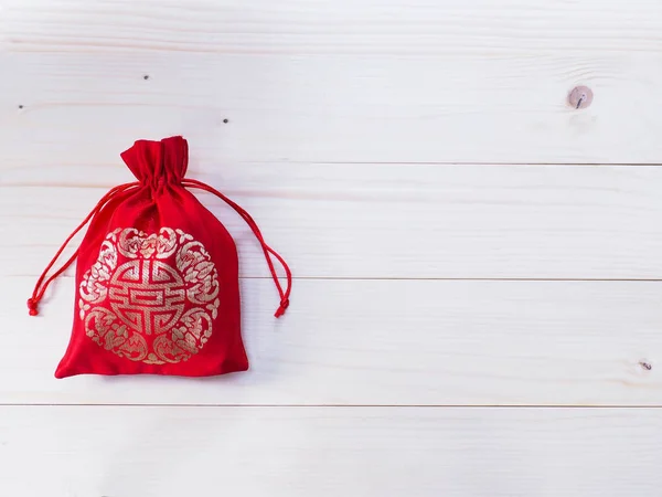 Bolso de dinero sedoso rojo con cuerda sobre fondo de madera —  Fotos de Stock