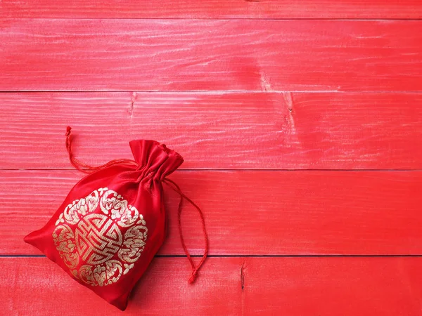 Bolso de dinero sedoso rojo con cuerda sobre fondo de madera —  Fotos de Stock