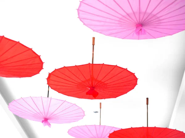 天井に掛かっている赤とピンクの傘. — ストック写真