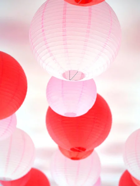 Lanternas vermelhas e rosa penduradas no teto . — Fotografia de Stock