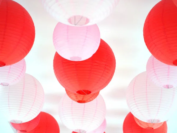 Lanternas vermelhas e rosa penduradas no teto . — Fotografia de Stock