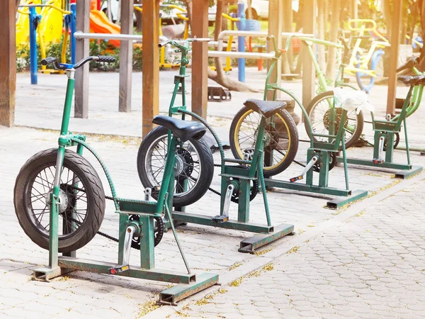 Row of metal outdoor exercise bikes.