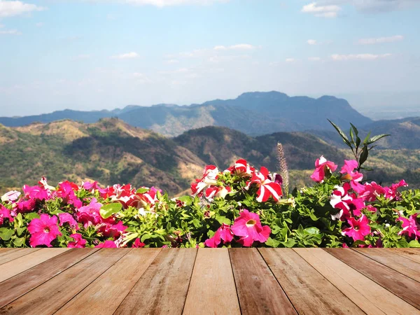 Fa asztali felett a magas hegyek háttérhez képest virágok — Stock Fotó