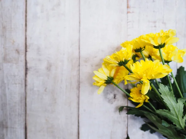 Gelbe Chrysanthemen blühen auf weißem Holz. — Stockfoto