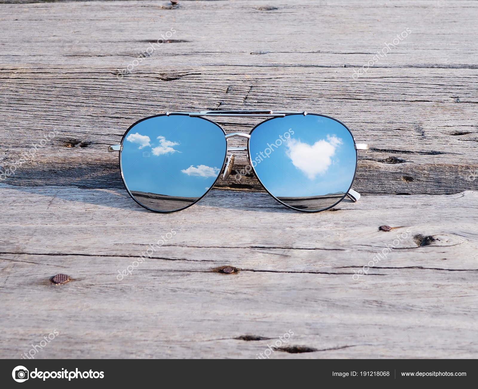 Reflection of blue sky and clouds heart shape in sunglasses Stock