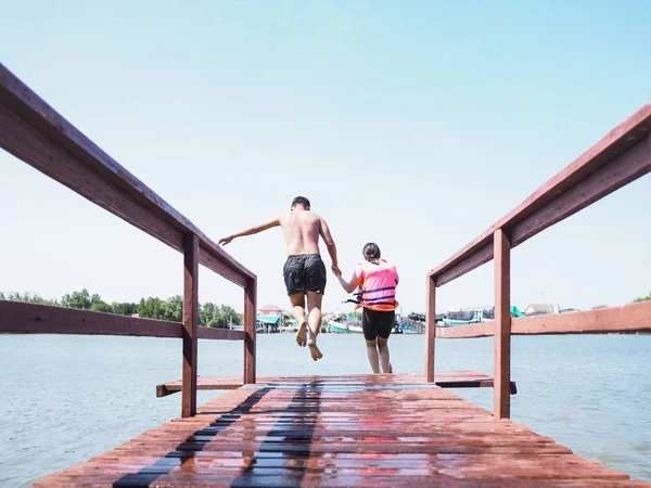 Asiatique homme et sa soeur sauter de pont en bois — Photo