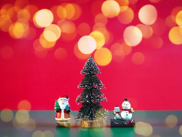 Маленький Санта-Клаус, снеговик и сосна на зеленый цвет над красным — стоковое фото
