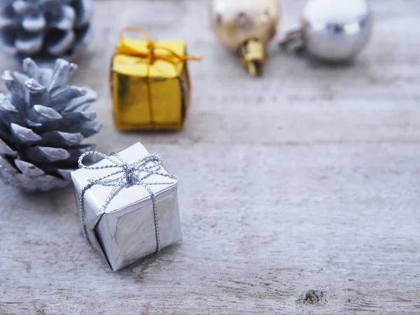 Подарочные коробки и серебряная сосновая шишка на белом винтажном фоне дерева — стоковое фото