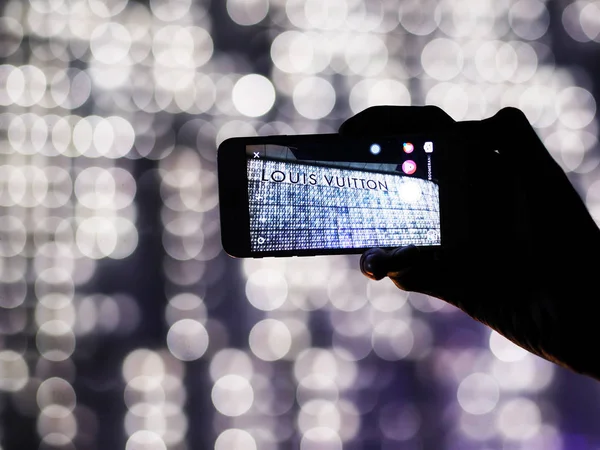 Turista tomar fotografía desde el teléfono móvil logo Louis Vuitton sujetador —  Fotos de Stock