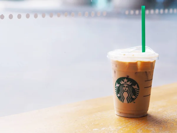 Starbucks tasse à café froide sur table en bois à proximité fenêtre en verre à — Photo