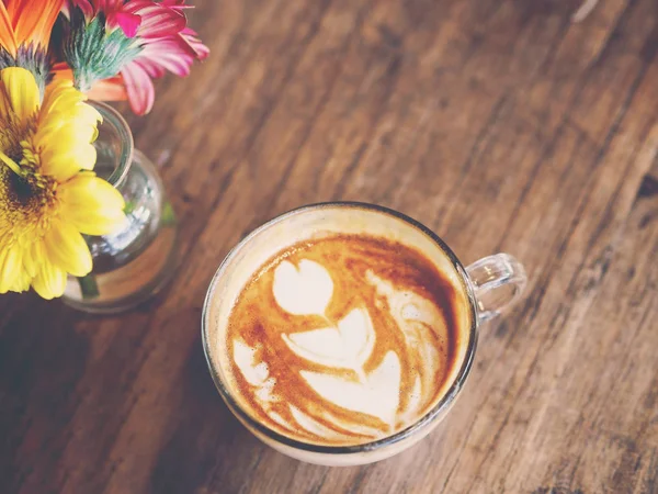 Filiżanka kawy z pianką mleczną typu latte na drewnianym stole, — Zdjęcie stockowe