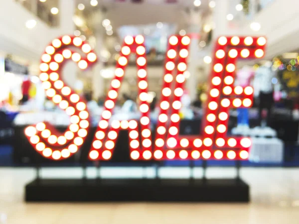 赤電球のアブストラクトぼかしの背景ショッピングデパートの床に販売 — ストック写真