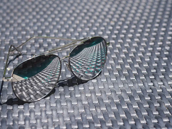 Zavřít Sluneční Brýle Odrazem Objektivu Nad Černou Tkanou Židli Vedle — Stock fotografie