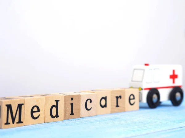 Close Wooden Blocks Wording Medicare Small White Ambulance Model Blue — Stock Photo, Image