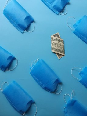 Mavi arka planda bir dolarlık Amerikan banknotları ve maskeleri