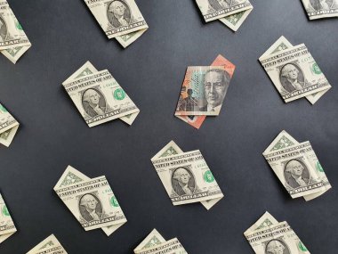 Bir dolarlık Amerikan banknotları ve siyah arka planda 20 dolarlık Avustralya banknotları.
