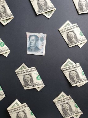 1 dolarlık Amerikan banknotları ve siyah arka planda 10 Yuan 'lık Çin banknotları.