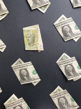 Bir dolarlık Amerikan banknotları ve siyah arka planda beş dinarlık Tunus banknotları.