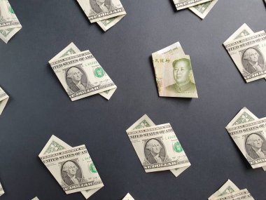 Bir dolarlık Amerikan banknotları ve siyah arka planda bir yuan Çin banknotu.