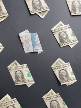 Bir dolarlık Amerikan banknotları ve siyah arka planda 2000 pezoluk Kolombiya banknotları.