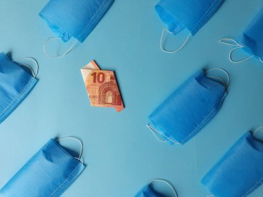 Mavi arka planda 10 avroluk Avrupa banknotu ve maskeler