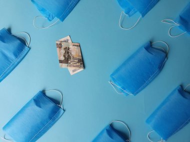 Mavi arka planda 50 ruble ve maskeli bir Rus banknotu.