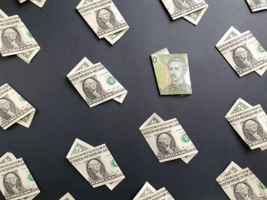 Bir dolarlık Amerikan banknotları ve siyah arka planda 1000 pesoluk Şili banknotları.